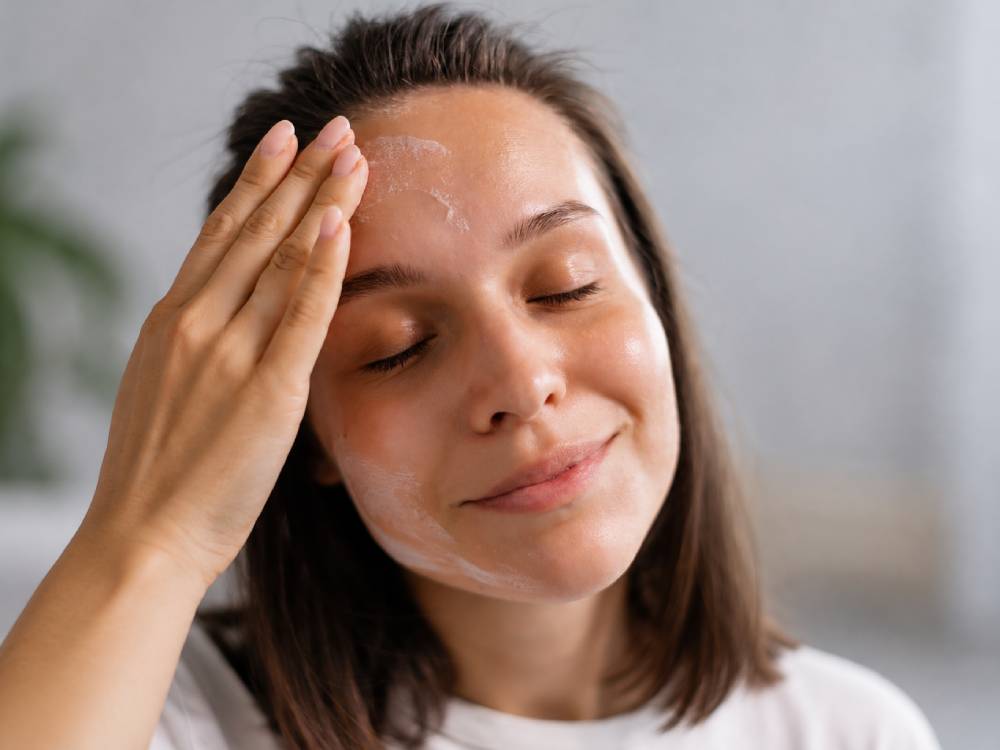 Mujer aplicando sérum con ácido hialurónico en el rostro como parte de su rutina de hidratación facial